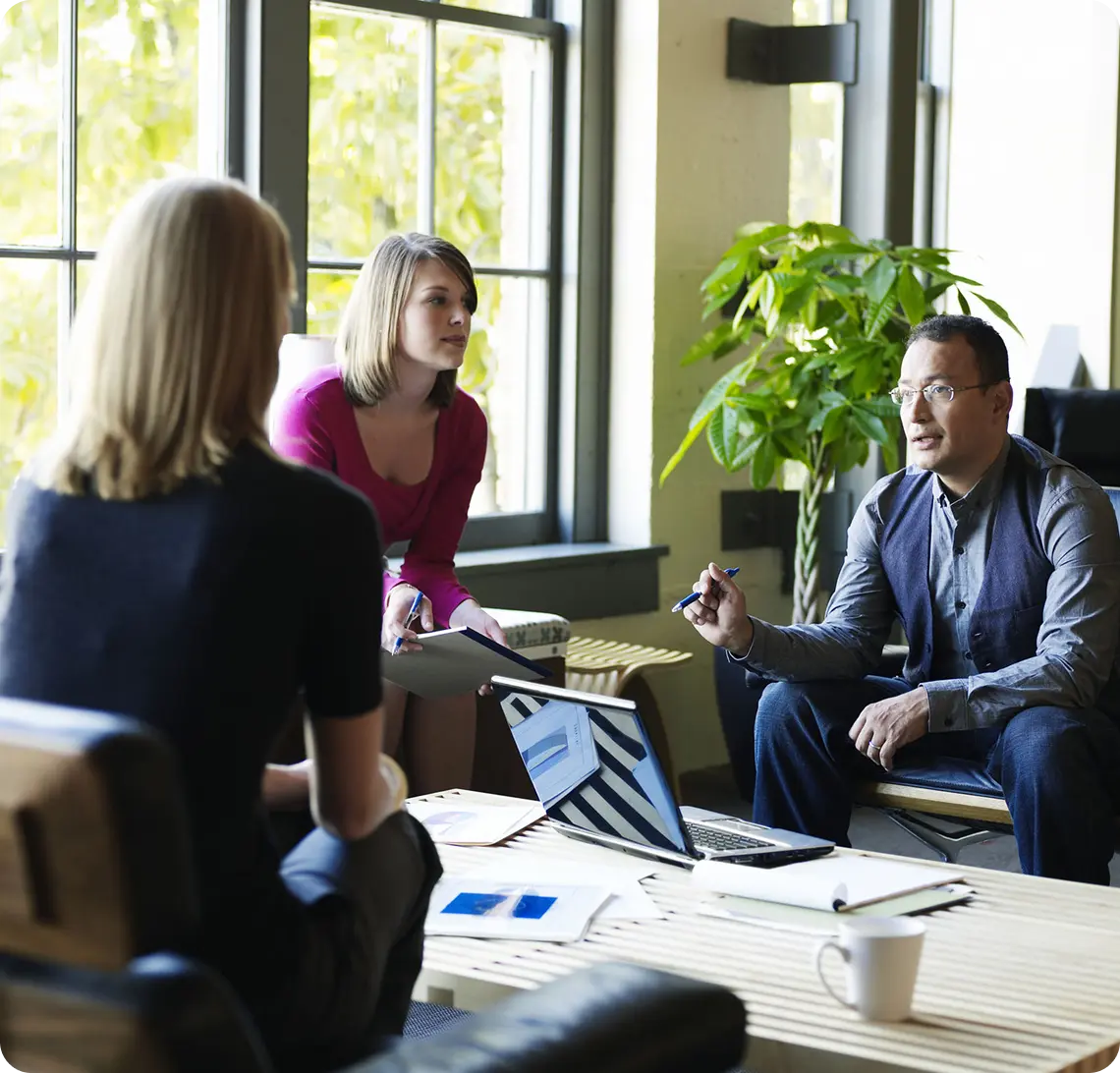 Office meeting with three people discussing