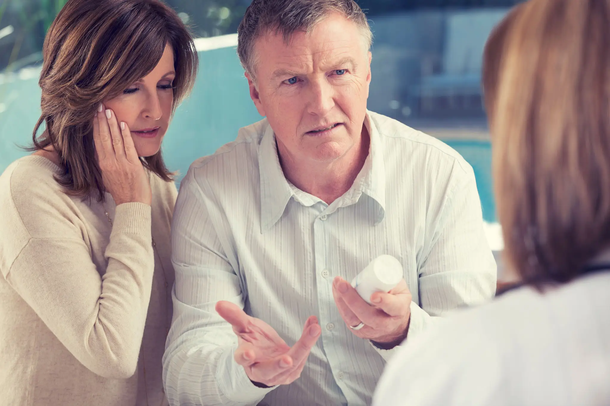 A man explaining something to two women in a serious discussion.