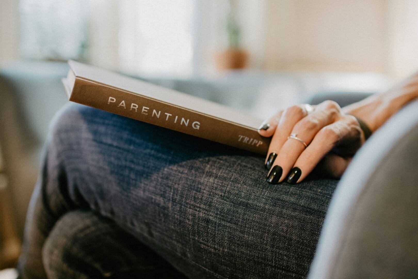 Person holding a parenting book, representing thoughtful support and guidance offered through co-parenting therapy in Seattle.