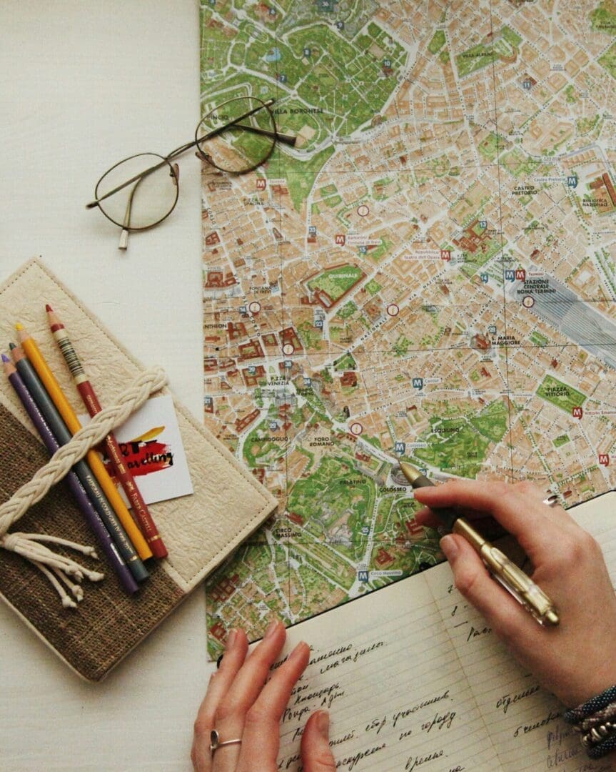 Hands writing in a journal beside a city map, reflecting the self-exploration and insight encouraged in emotion-focused therapy in Seattle.