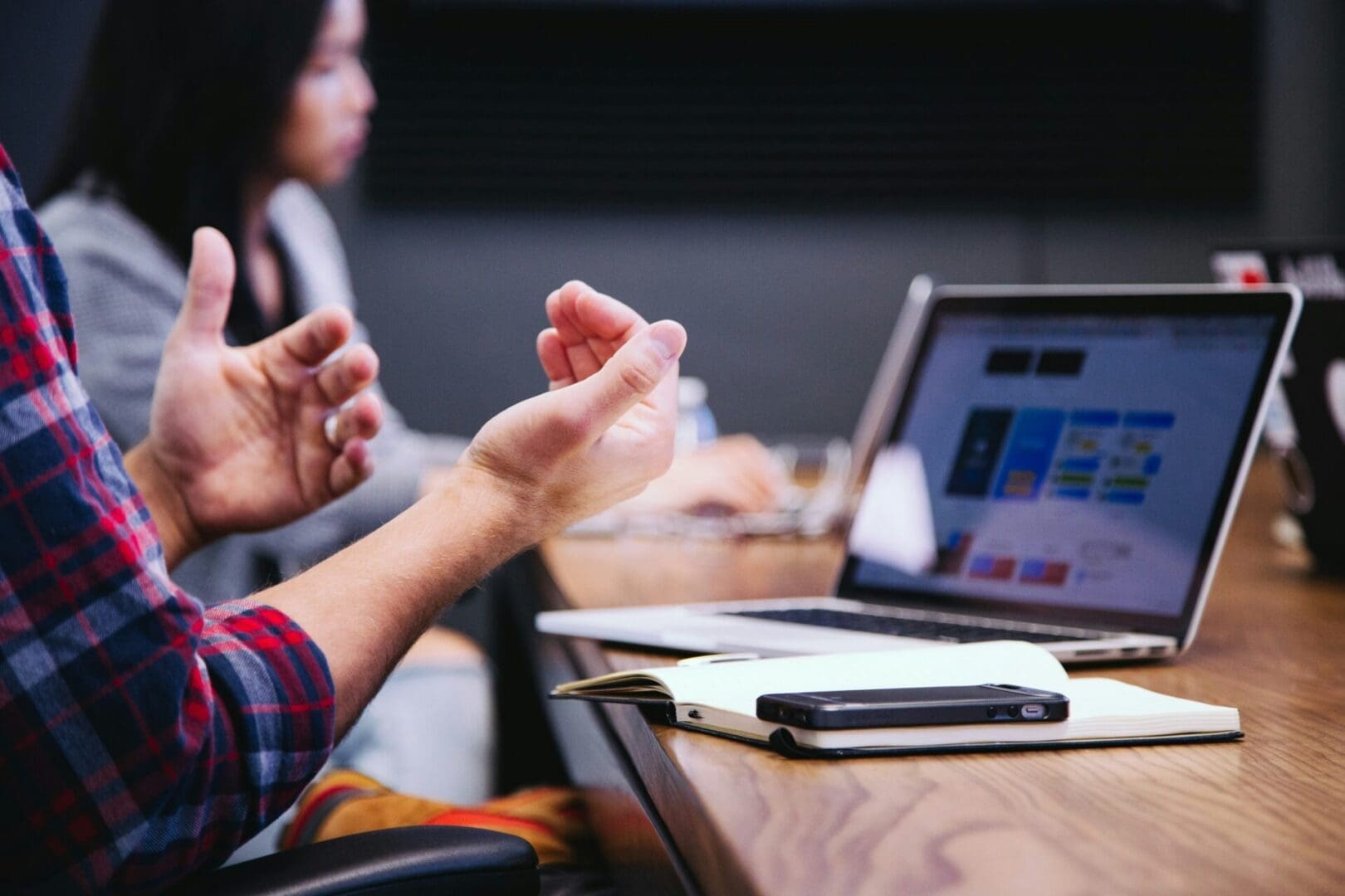 Professional gesturing during a virtual work discussion, reflecting the self-doubt and performance pressure addressed in virtual imposter syndrome therapy.