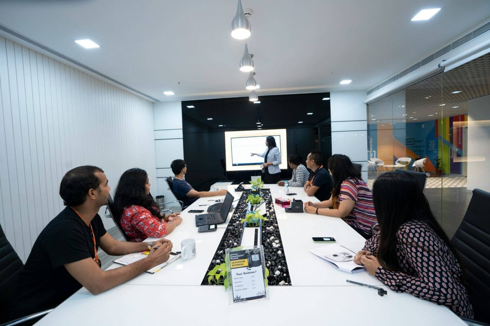 Team meeting in a modern conference room, representing workplace pressure and self-doubt explored in imposter syndrome therapy in Washington.