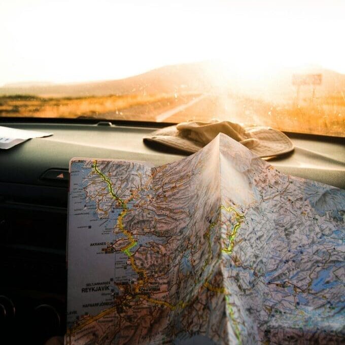 Hand holding a map inside a car on an open road, symbolizing direction and support through virtual emotion-focused therapy in Seattle.